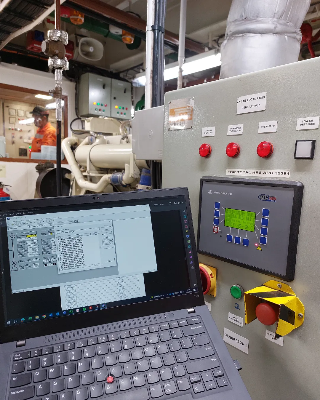 Technician performing diagnostics and sensor calibration on a ship's main engine automation system.